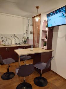 a room with a table and chairs and a tv at GARSONIERA DANIA&PETRU 1 in Târgu Ocna