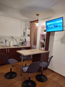 a room with a table and two chairs and a tv at GARSONIERA DANIA&PETRU 1 in Târgu Ocna