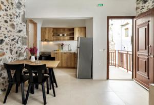 a kitchen with a table and chairs and a refrigerator at Mirthia Apartments in Myrthios