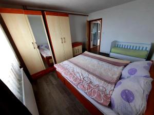 Dormitorio pequeño con cama y espejo en Kuća na dan Vrla strana en Bosansko Petrovo Selo