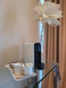 a glass table with a coffee maker and two cups at Hotel Carboneras Cabo de Gata by MIJ in Carboneras