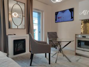 a living room with a fireplace and a table and chairs at Piotrkowska.eu Apartament Romantica in Łódź