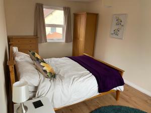 a bedroom with a bed with white sheets and a window at Spacious first floor apartment in the centre of Church Stretton with free parking in Church Stretton