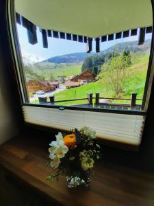 una ventana con un ramo de flores sobre una mesa en 2-Zimmer Ferienwohnung-Einklang im schönen Südschwarzwald en Todtnau