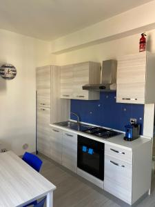a kitchen with white cabinets and a stove top oven at Jak's Home Laigueglia in Laigueglia