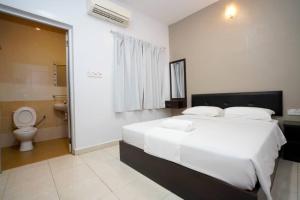 een slaapkamer met een groot bed en een toilet bij CK Hotel in Lumut