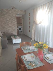 una mesa de comedor con platos y flores. en Igli apartments, en Arkasa