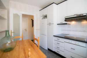 cocina con mesa de madera y armarios blancos en Antiguo Horno de María y Mielgo, en Muelas del Pan