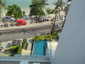 uma vista para uma rua com motocicletas e um camião vermelho em The Front Hotel and Apartments em Praia de Patong