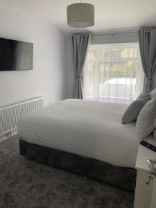 um quarto com uma grande cama branca e uma janela em Stonehaven em Kilkenny