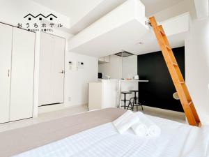 a white bedroom with a bed and a kitchen at OUCHI HOTEL Fujimi in Hiroshima