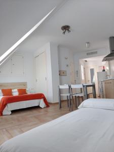 a white room with two beds and a table at Ático by Alhaurín Loft City Center in Alhaurín de la Torre
