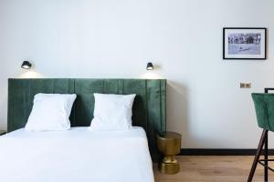 a bedroom with a bed with a green headboard at Florella Croisette Apartment in Cannes