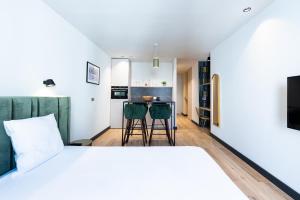 een slaapkamer met een bed en een keuken met een tafel bij Florella Croisette Apartment in Cannes