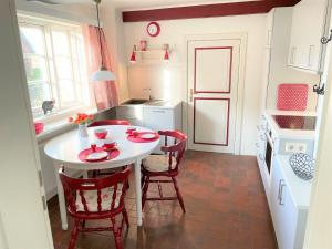 a small kitchen with a white table and chairs at Deichblick in Utersum