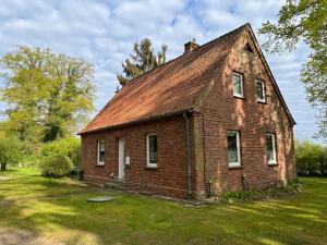 an old brick house with a roof on a field at Diershof Walsrode in Walsrode
