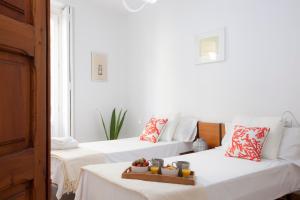 バレンシアにあるSingularStays Roterosの白い壁の客室内のベッド2台