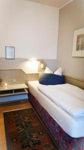 um quarto de hotel com uma cama e um tapete em Hotel Garni Zur Traube em Höhr-Grenzhausen