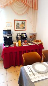 a table with a red table cloth with food on it at Hotel Garni Zur Traube in Höhr-Grenzhausen