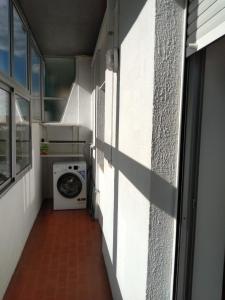 a laundry room with a washing machine and a window at Alojamento Almirante in Viseu