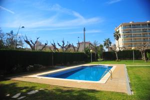 a swimming pool in a yard next to a building at Cambrils Puerto in Cambrils