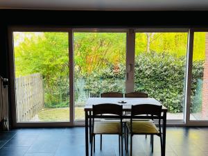 a dining room table with two chairs in front of a window at L'EVEIL in La Louvière