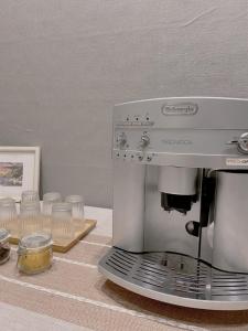 - une machine à café assise sur un comptoir avec des verres dans l'établissement Wangs Hostel, à Tainan