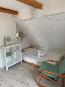 a small bedroom with a bed and a chair at Green place in Žetale
