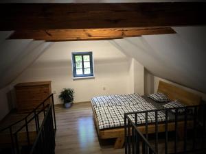 Pokój na poddaszu z łóżkiem i oknem w obiekcie Mezonetový apartmán s terasou na samotě v lese w mieście Vlkava