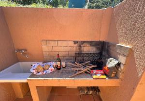 a outdoor grill with a bottle of wine and alcohol at Veranda sul Paradiso in Costa Paradiso