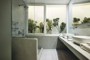 baño con bañera, lavabo y ventana en AK Mykonos en Mykonos