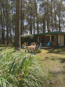 レオンにあるLes Villages sous les Pins, piscines chauffées, Les Arbousiersの小屋の前のテーブルに座る人々