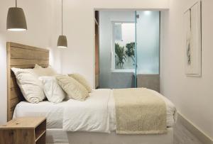 1 dormitorio con 1 cama con sábanas y almohadas blancas en AK Mykonos en Mykonos
