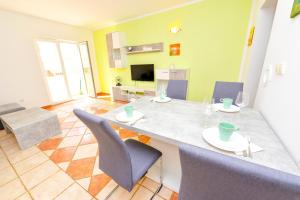 cocina y sala de estar con mesa y sillas en Apartment Dadi, en Novalja