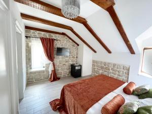 - une chambre avec un lit et un mur en pierre dans l'établissement Bed&Breakfast Sorgo Palace, à Ston