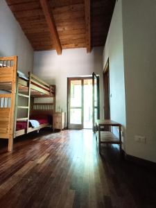 Pokój z 2 łóżkami piętrowymi i drewnianą podłogą w obiekcie Cascina Govean w mieście Alpignano