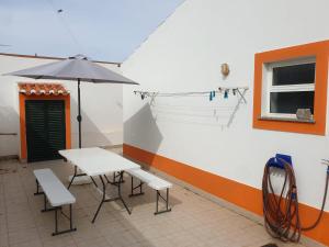 羅吉爾的住宿－Casa Pompona 1，桌子、椅子和雨伞