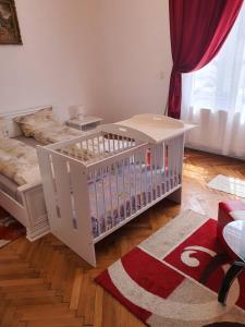 a baby crib in a room with a couch at Apartament Enescu in Timişoara