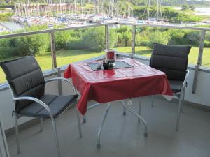 a table and chairs on a balcony with a view of a marina at Smucke Stuuv I in Glücksburg