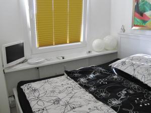 グリュックスブルクにあるSmucke Stuuv Iのベッドルーム1室(ベッド1台、モニター、窓付)