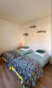 two beds in a room with fish on the wall at Appartement Vue mer en plein centre de Cargese in Cargèse