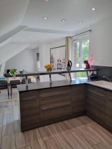 a kitchen with wooden cabinets and a counter top at Stableyard cottages in Lamorlaye