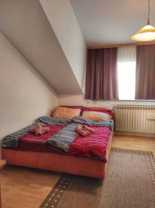 a bedroom with a bed with two people laying on it at Apartman Anita in Varaždin