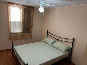 - une chambre avec un lit, un ventilateur de plafond et une fenêtre dans l'établissement Costa Saracena Sole, Mare e Relax, à Augusta