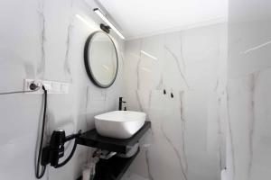 a white bathroom with a sink and a mirror at Palazzo Vista Suite&Spa in Thessaloniki +27 photos