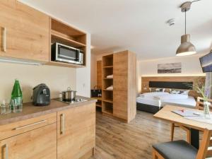 a bedroom with a bed and a kitchen with a table at Studio in Austria with Panorama Sauna in Klösterle am Arlberg