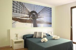 a bedroom with a bed with a painting of a windmill at 103 Boutique Hotel Stintino in Stintino