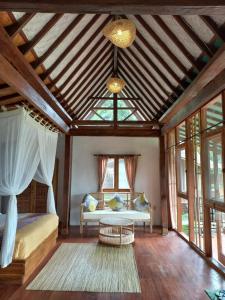 ein Wohnzimmer mit einem Bett und einem Tisch in der Unterkunft Sang Tirta Resort in Penebel