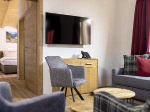 a living room with a chair and a tv at Welcoming holiday home in Matrei in Osttirol with balcony in Matrei in Osttirol