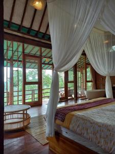 a bedroom with a bed with white drapes at Sang Tirta Resort in Penebel
